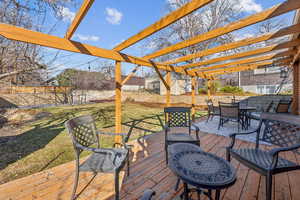 Deck featuring a yard, outdoor dining space, a fenced backyard, and a pergola