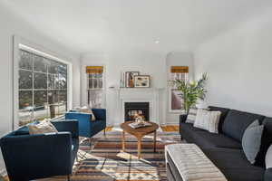 Living room featuring a glass covered fireplace, wood finished floors, and baseboards