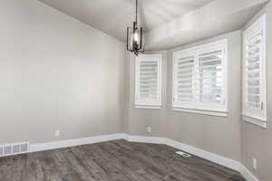 Unfurnished dining area featuring visible vents and baseboards