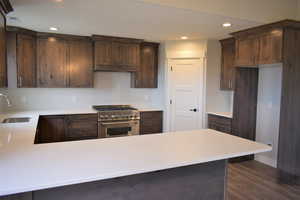 Kitchen featuring a sink, recessed lighting, high end range, and light countertops