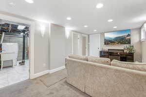 Living area featuring recessed lighting, light carpet, and baseboards