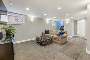 Living area featuring carpet, recessed lighting, baseboards, and stairs