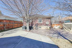 Rear view of property with a patio area, a fenced backyard, and brick siding