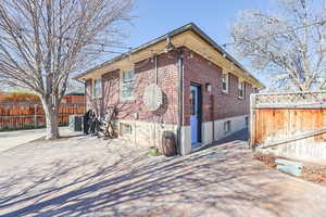 View of home's exterior featuring brick siding and fence