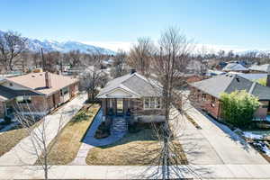 View of front of home with a mountain view, a shingled roof, brick siding, driveway, and a residential view