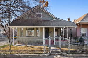 Front view of house featuring a fenced front yard, covered porch.