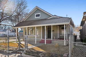 Front view of home with a fenced front yard, covered porch.