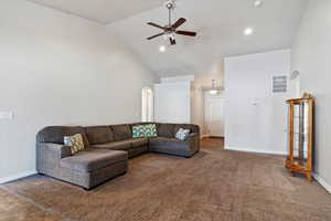 Carpeted living area with baseboards, arched walkways, a ceiling fan, high vaulted ceiling, and recessed lighting