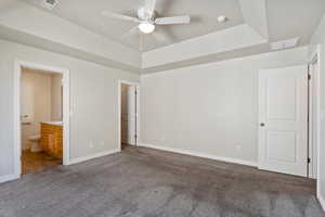 Unfurnished bedroom featuring visible vents, a raised ceiling, and carpet flooring