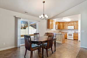 Dining room featuring baseboards, visible vents, vaulted ceiling, and a notable chandelier