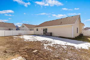 Rear view of property featuring fence and central AC