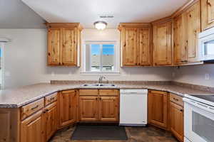 Kitchen with a peninsula, white appliances, a sink, visible vents, and brown cabinets