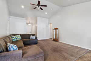 Carpeted living room with ceiling fan, high vaulted ceiling, recessed lighting, visible vents, and baseboards