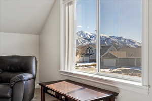 Sitting room with carpet floors, a mountain view, and vaulted ceiling