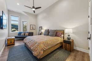 Bedroom featuring baseboards, a ceiling fan, lofted ceiling, wood finished floors, and recessed lighting