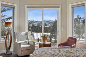 Bedroom featuring multiple windows, wood finished floors, a mountain view, and baseboards