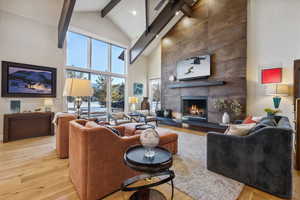 Living area featuring beamed ceiling, wood finished floors, and a tile fireplace