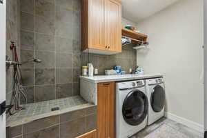 Clothes washing area with baseboards and separate washer and dryer