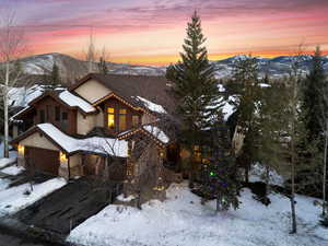 View of front of property featuring a garage, stone siding, and a mountain view