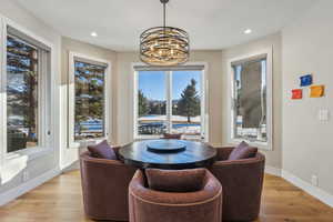 Dining room featuring light wood-style floors, baseboards, an inviting chandelier, and recessed lighting