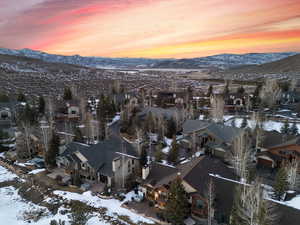 Snowy aerial view featuring a mountain view and a residential view