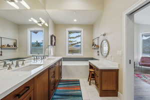 Bathroom featuring double vanity, a sink, a bath, and tile patterned floors