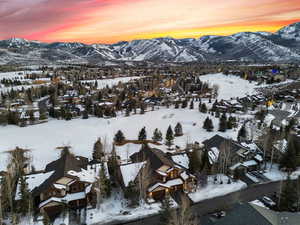 Snowy aerial view featuring a residential view and a mountain view