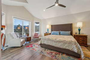 Bedroom featuring ceiling fan, baseboards, vaulted ceiling, and wood finished floors