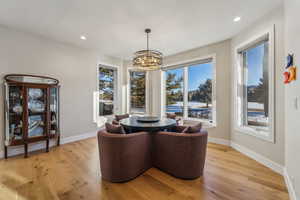 Dining area with recessed lighting, baseboards, a notable chandelier, and light wood finished floors