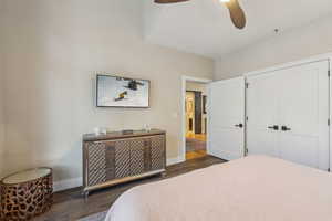 Bedroom featuring ceiling fan, a closet, baseboards, and dark wood-style flooring