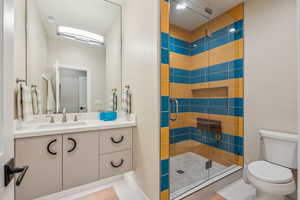 Bathroom featuring visible vents, toilet, tile patterned floors, vanity, and a shower stall