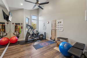 Exercise room featuring recessed lighting, a ceiling fan, wood finished floors, high vaulted ceiling, and baseboards