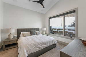 Carpeted bedroom with ceiling fan, baseboards, and vaulted ceiling