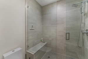 Full bath with toilet and a shower stall