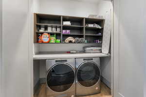 Washroom with laundry area, baseboards, independent washer and dryer, and light wood finished floors