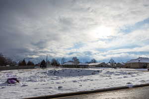 Yard layered in snow featuring a residential view