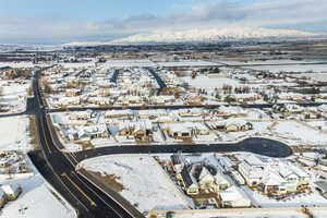 Snowy aerial view featuring a residential view and a mountain view