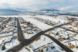 Snowy aerial view featuring a residential view and a mountain view