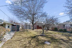 View of yard featuring fence, a storage unit, and an outdoor structure