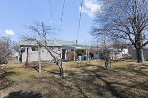 Rear view of property with metal roof and a lawn