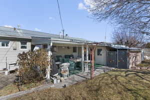 Back of property featuring a patio area, metal roof, and a lawn