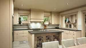 Kitchen with a breakfast bar, dark countertops, a center island, and a sink