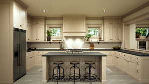 Kitchen featuring dark countertops, a kitchen bar, built in refrigerator, and a center island