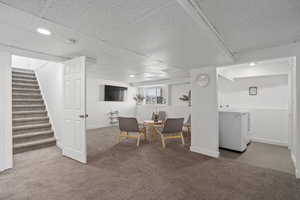 Interior space with stairs, carpet floors, washer / dryer, and baseboards