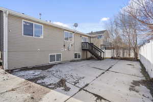 Back of property featuring fence, stairway, and a patio