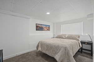 Bedroom with carpet flooring, a paneled ceiling, and baseboards