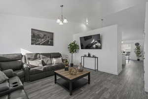 Living room with lofted ceiling, baseboards, and wood finished floors