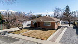 Bungalow with a shingled new roof, a mountain view, a front lawn, and 2 driveways