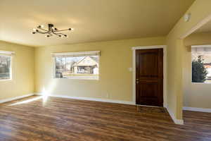 Entrance foyer featuring dark wood-style floors, plenty of natural light with large windows,