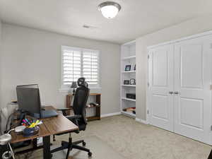 Office space featuring carpet, visible vents, and baseboards